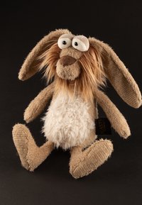Plush rabbit toy with long ears and a fluffy white belly. Soft tan fabric, stitched details, and button eyes. Tag on side reads "Beasts Town."
