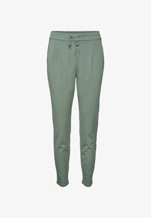 Roheline jooksupüksid, millel on paelavöö, kaks esikotti, sile tekstuur ja kitsenevad jalad. Materjal tundub pehme ja veniv.