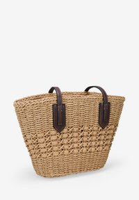 Bolsa de paja trenzada con forma trapezoidal, asas de cuero marrón oscuro y un patrón texturizado en el cuerpo.