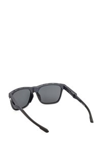 Black sunglasses with square frames, matte finish, and gray lenses. Features vented temples and angular design for a sporty look.