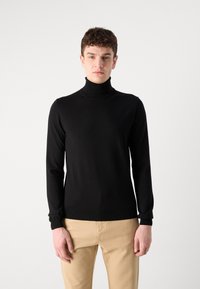 Pulover negru cu guler înalt, cu mâneci lungi, realizat dintr-un material neted și elastic. Prezintă o croială ajustată și manșete și tiv cu model crenelat.