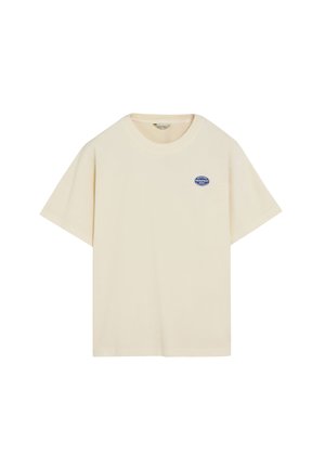 Camiseta beige de manga corta con cuello redondo y pequeño logo ovalado azul en el pecho izquierdo que dice "PEACHES FRESHFRUIT 0593".