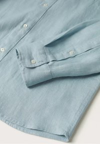 Jasnoniebieska lniana koszula z zapięciem na guziki, białymi guzikami i mankietem zagiętym, gładką fakturą oraz subtelnymi detalami szwów.