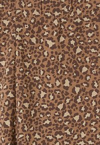 Leopardenmusterstoff mit einer kräftigen Braun- und Beigetöne-Palette, einer strukturierten Oberfläche und einem unregelmäßigen, variierenden Punktmuster.