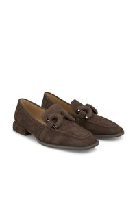 Braune Wildleder-Loafer mit runder Zehenpartie, ausgestattet mit einem dekorativen Riemen und silbernen Hardware-Elementen. Niedriger Blockabsatz. Glatte Innenauskleidung.