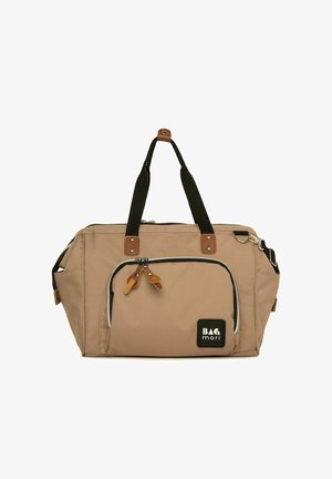 Borsa da viaggio in tessuto beige con accenti neri, manici superiori e chiusura con zip. Presenta una tasca frontale con linguette in pelle e una patch con logo.
