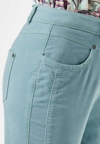Lichtblauwe denim broek met een hoge taille, gestructureerde stof, zijzakken en contrasterende stiksels langs de naden.