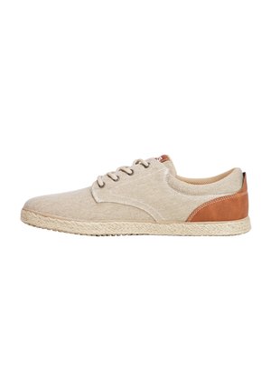 Scarpe di tela beige con retro in pelle color cuoio, caratteristiche includono punta rotonda, cinque fori per i lacci e suola in juta testurizzata. Rifiniture cucite sulla parte superiore.