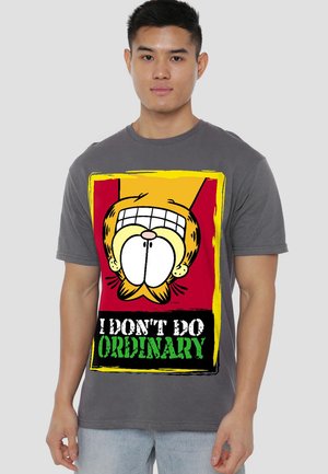 Gray cotton t-shirt featuring a cartoon character with a large grin. Text below reads "I DON'T DO ORDINARY" in bold green and black.