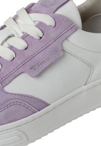 Sneaker bianca e lavanda realizzata in materiali scamosciati e in pelle. Presenta lacci bianchi, suola testurizzata e un logo sul pannello lavanda.