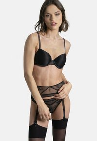 Ensemble de lingerie noire comprenant un soutien-gorge rembourré lisse avec bretelles ajustables, une culotte en dentelle taille haute et des jarretelles attachées.