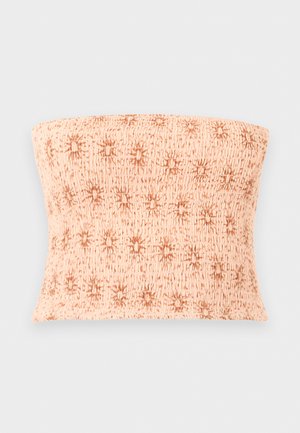 Haut bandeau beige froncé avec un motif général d'étoiles brunes, sur un fond gris clair uni.