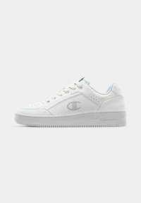 White leather sneakers with a smooth texture, round toe, perforated detailing, and a subtle logo on the side. Thick rubber outsole.