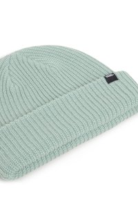 Hellgrüner gestrickter Beanie mit geripptem Muster, ausgestattet mit einem umgeschlagenen Bund und einem kleinen schwarzen Etikett mit weißer Schrift.