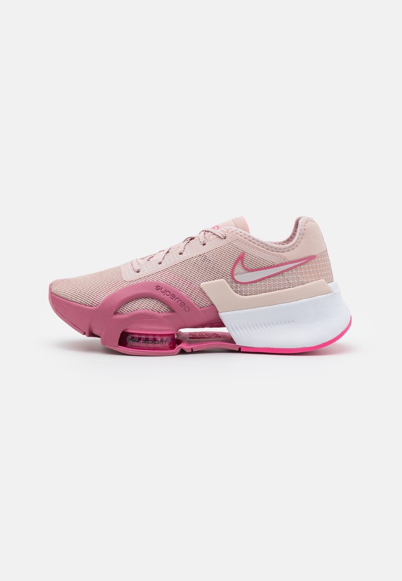 Chaussure de course rose clair et rose avec dessus en mesh, unité de semelle à air visible et une semelle intermédiaire blanche avec le logo Nike Swoosh rose.