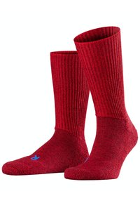 Calze rosse a costine realizzate in materiale strutturato, con punta e tallone rinforzati e un piccolo logo blu sulla suola di una calza.