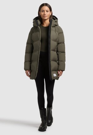 Oliivroheline puffer-jakk kapuutsiga, ees lukuga ja külje taskutega. Mustad aktsendid luku ääres. Kandmine tumeda pluusi ja mustade retuuside peal.