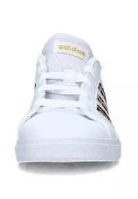 Sneaker bianca con logo adidas dorato, linguetta in mesh e tre strisce laterali. Punta arrotondata e suola in gomma testurizzata. Design casual con lacci.