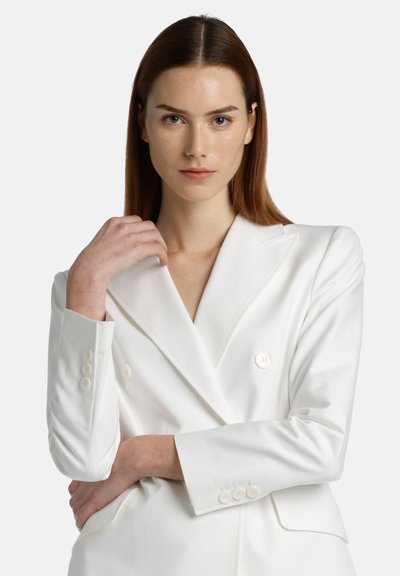 Dubbelzijdige witte blazer van gladde stof, met pieklapels en vier knoopaccenten op de mouwen. Getailleerde pasvorm met een gestructureerd ontwerp.