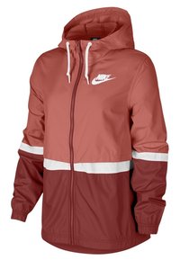 Veste coupe-vent Nike corail, avec un design en blocs de couleurs divisées comprenant des sections blanches et rouge foncé. Légère, fermeture éclair frontale, capuche ajustable.