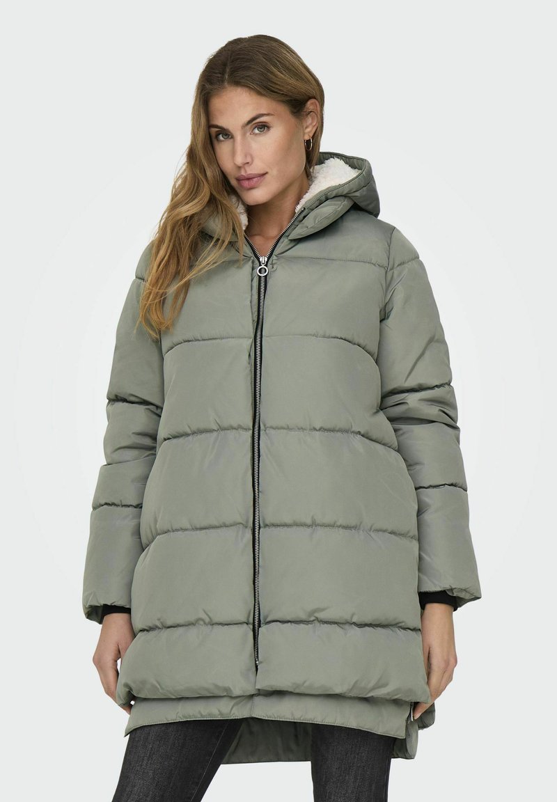 Light green puffer jacket with a hood, featuring a full front zipper, wide horizontal seams, and plush lining. Long sleeves and extended hem.