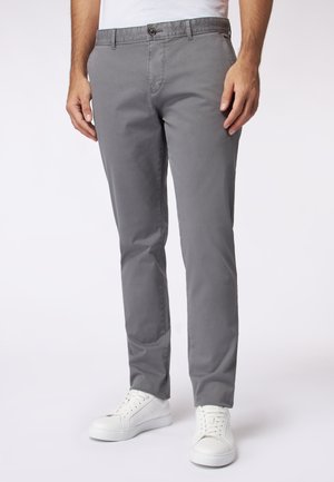 Grijze chinos van katoen, met een rechte pasvorm, knoopsluiting en zijzakken, gecombineerd met witte sneakers en een eenvoudig T-shirt.