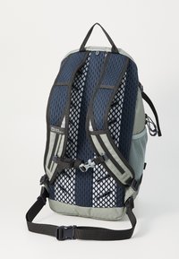 Zaino con design in rete in blu scuro e grigio, dotato di spallacci imbottiti, fibbie regolabili e un manico di trasporto ben visibile sulla parte superiore.