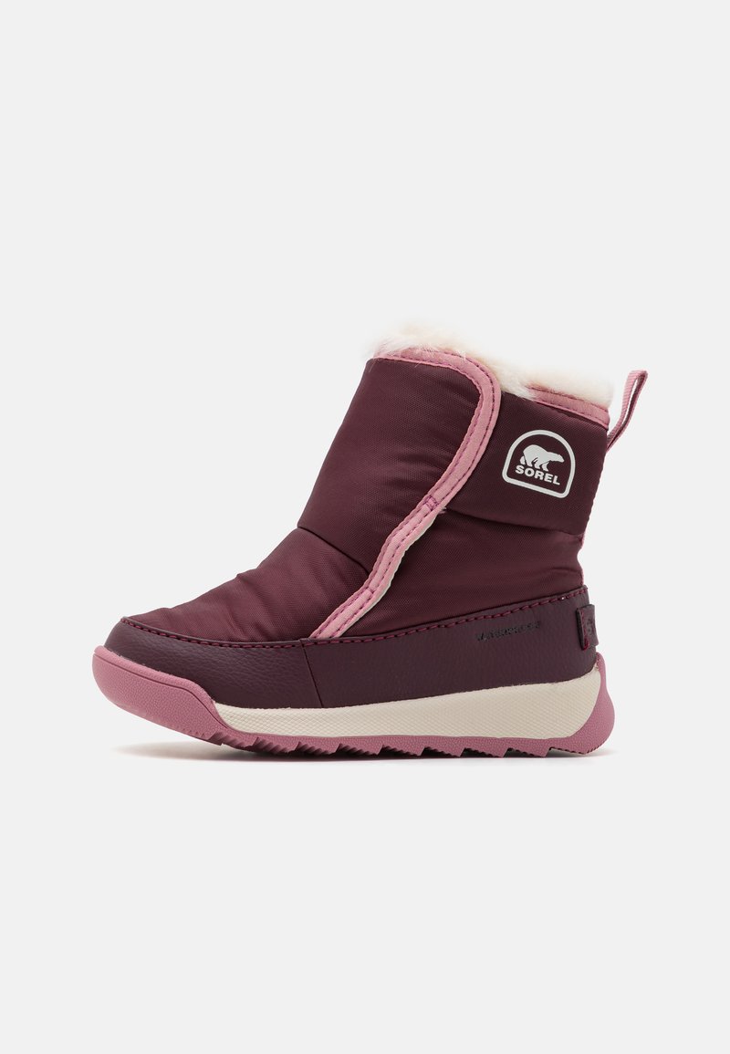 Botte bourgogne imperméable avec accents roses, col en fausse fourrure, semelle en caoutchouc et logo sur le côté. Possède un design surpiqué et une languette de traction.