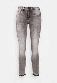 Jeans skinny de denim gris con un acabado desgastado, que cuentan con una cinturilla estándar, cinco bolsillos y dobladillos deshilachados en los tobillos.