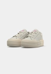 Pair of off-white platform sneakers with chunky soles, lace-up fronts, and pink logo details on tongue and heel against a white background.