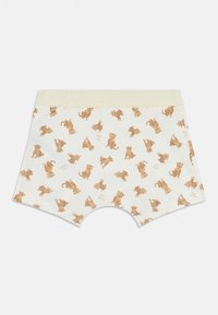 Shorts blancs pour bébé avec une ceinture rayée jaune clair, ornés de petites illustrations de léopards tachetés marron et du texte "Petit bateau".