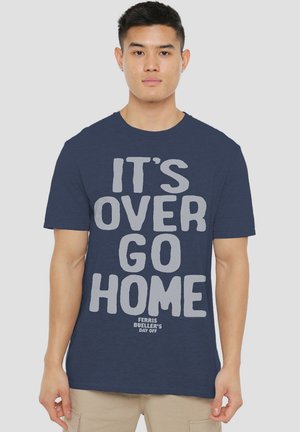 Navy blue cotton t-shirt featuring bold gray text: "IT'S OVER GO HOME" with "FERRIS BUELLER'S DAY OFF" at the bottom. Short sleeves, crew neck.