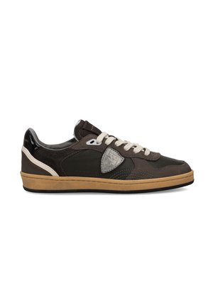 Low-top casual sneaker in dark brown with beige laces, tan rubber sole, and a silver emblem on the side panel against a white background.