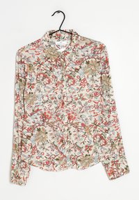 Kukkaroidun pitkähihasen paidan, jossa on vaalean kerma tausta ja värikkäitä punaisia, sinisiä ja vihreitä kukkia. Napitetaan edestä ja siinä on klassinen kaulus.