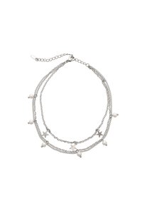 Collar de plata en capas que presenta encantos y cuentas en forma de estrella. Diseño de cadena con enlaces de plata alternos y elementos decorativos.