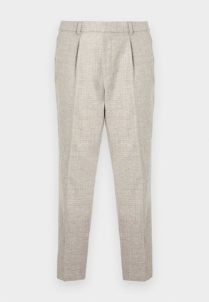 Pantalons ajustés gris clair en tissu texturé, avec une taille plate, deux plis à l'avant et des jambes effilées, se terminant juste au-dessus des chevilles.