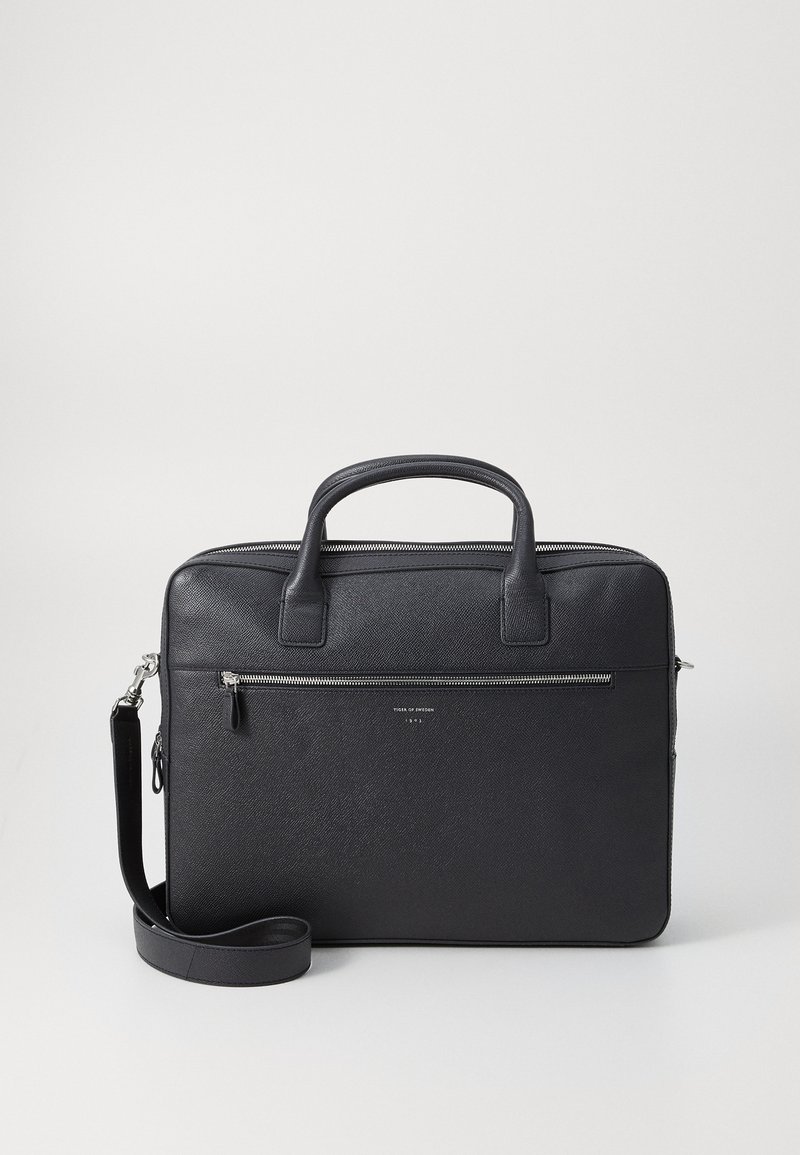 Black leather briefcase with two handles, removable shoulder strap, textured finish, front zip pocket, and minimalist design.