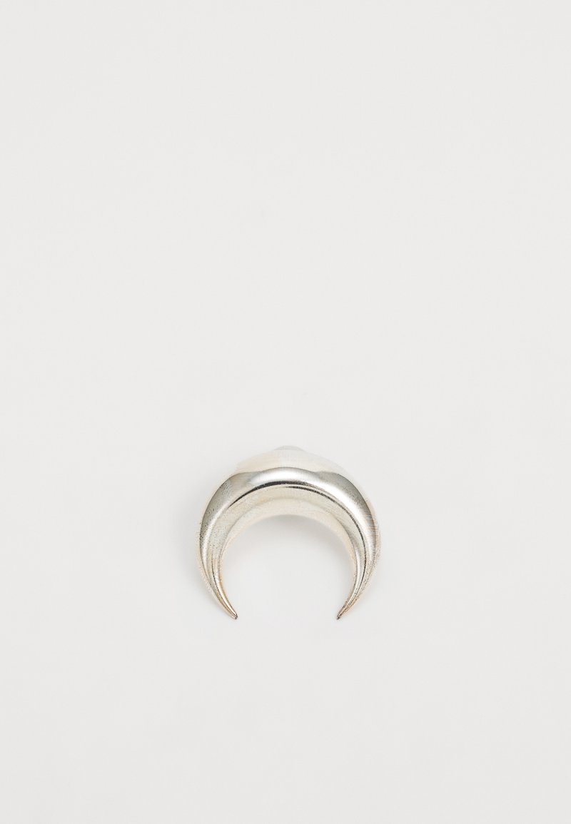 Anillo plateado en forma de media luna con una textura pulida y bordes suaves y curvados, creando un diseño minimalista.