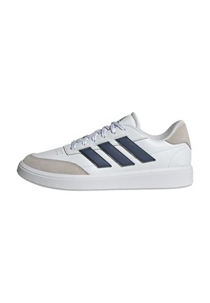 Zapatillas blancas con rayas azul marino, acentos de gamuza y suelas de goma. Presentan cordones redondos y perforaciones para transpirabilidad.