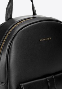 Černý kožený batoh zaobleného tvaru s zlatým zipem a zlatým logem 'WITTCHEN'. Hladký povrch s minimalistickým designem.