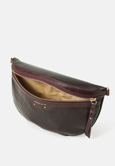 Pochette en cuir de couleur bordeaux foncé avec des accessoires en métal doré. Dispose d'une fermeture éclair et d'une doublure en tissu beige. Forme légèrement arrondie.
