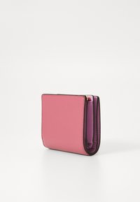 Portefeuille plié en cuir rose texturé avec un intérieur violet. Caractéristiques des bords noirs contrastés et une forme rectangulaire compacte.