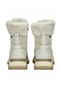 Witte faux fur gevoerde laarzen met een zachte leren buitenkant. Heeft een gestructureerde tan zool en kleine merktekens op de hak en zijkant.