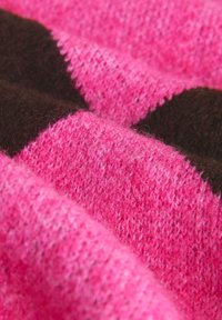 Tissu tricoté présentant des rayures larges alternées de rose vif et de brun foncé. Fil doux et texturé avec une apparence duveteuse.