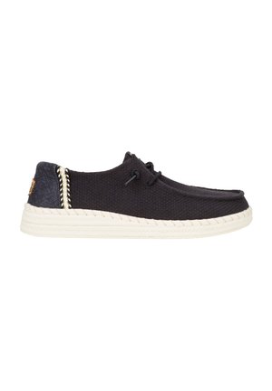 Scarpe da ginnastica nere con tomaia testurizzata, suola intermedia intrecciata bianca e dettagli di cucitura a contrasto sul tallone. Presentano occhielli per i lacci.