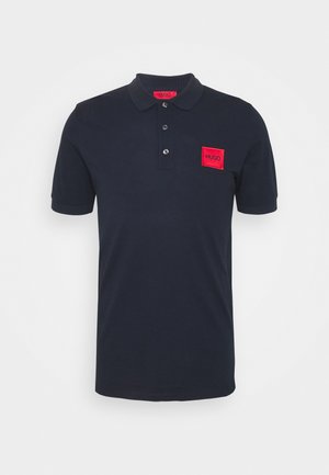 Polo shirt blu navy in cotone, con colletto a coste, patta con tre bottoni e una patch rettangolare rossa sul petto sinistro.
