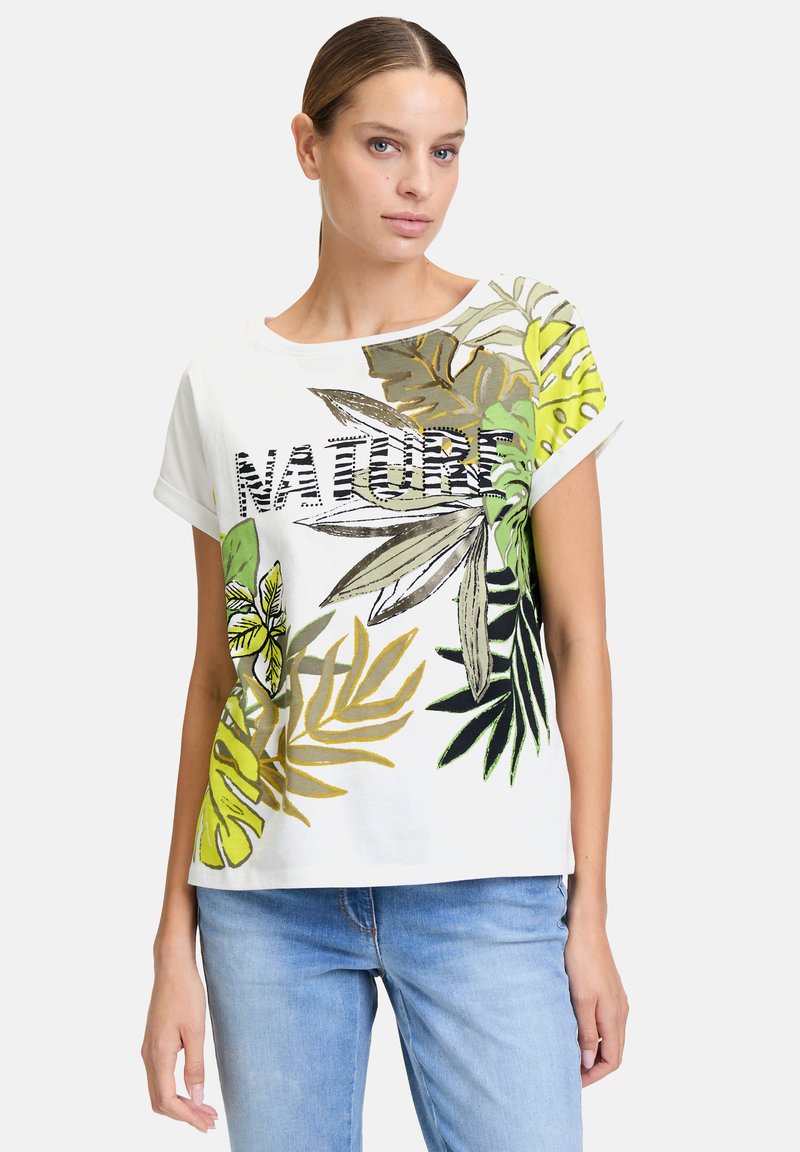 Biała koszulka z krótkim rękawem z zielonymi i żółtymi nadrukami liści. Napis "NATURE" z przodu w kolorze czarnym, o luźnym kroju i miękkiej fakturze.