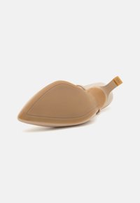 Scarpa con tacco alto beige con punta affusolata, finitura liscia e lucida, e tacco sottile. Suola in gomma con marchio sul tacco.