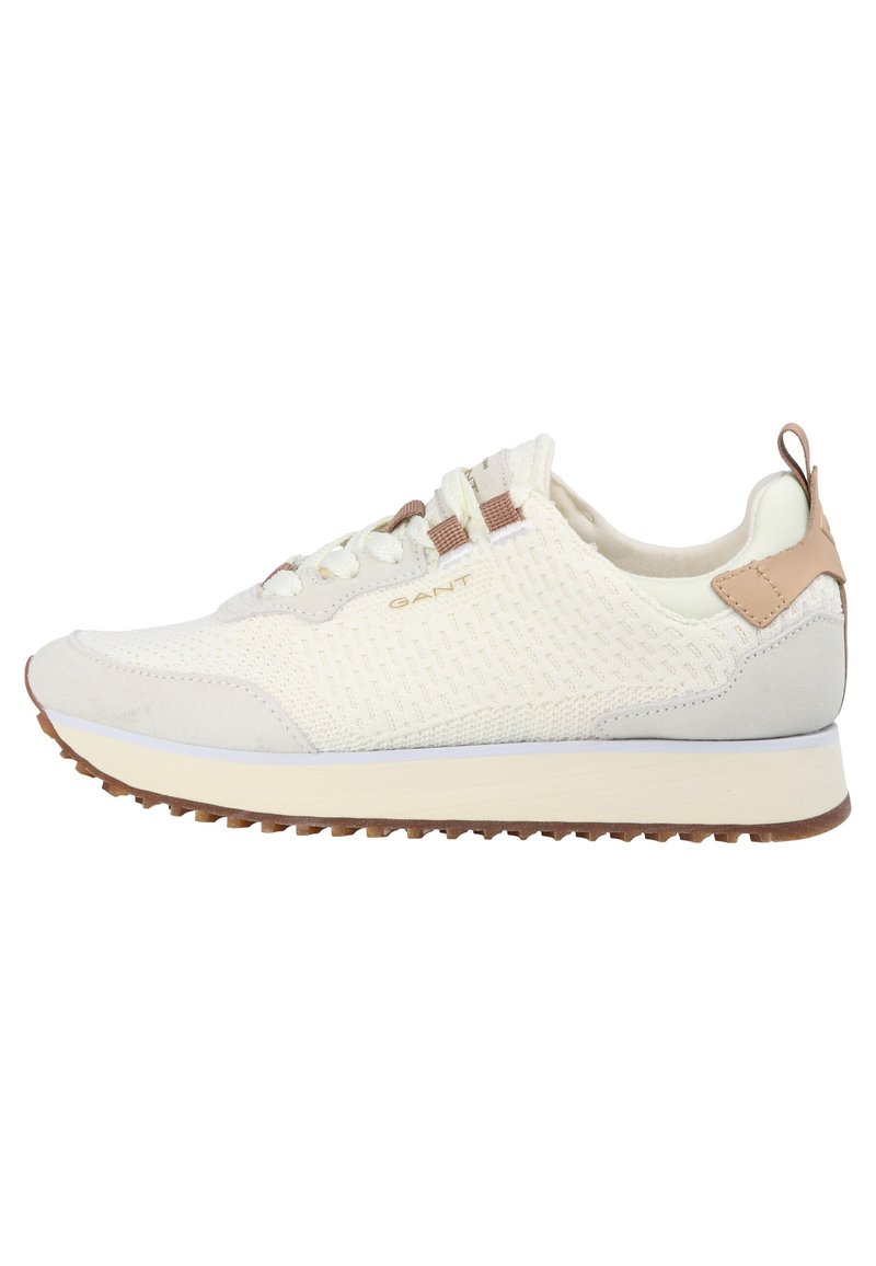 White athletic sneakers with a mesh and suede upper, light brown accents, rounded toe, and a textured rubber sole. Logo visible on the side.
