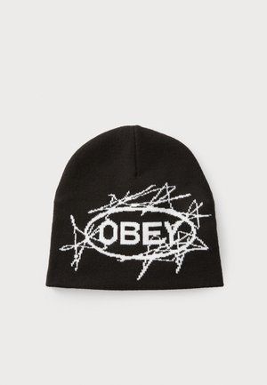 Black knit beanie featuring a white logo surrounded by a barbed wire graphic, creating a textured pattern. Soft material with a snug fit.
